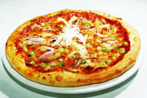 The ayam masak merah pizza is a delectable mixture of chicken chunks, green peas, onion, red and green capsicum in a savoury tomato and chilli sauce.